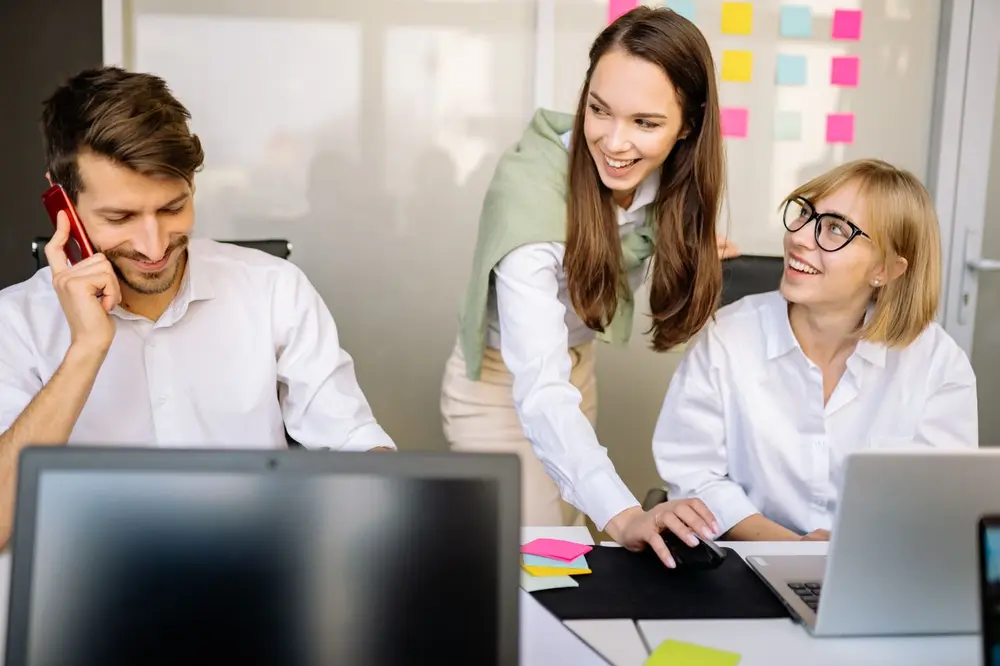 Team von Marlin Immobilien arbeitet gemeinsam und gut gelaunt im Buero zusammen