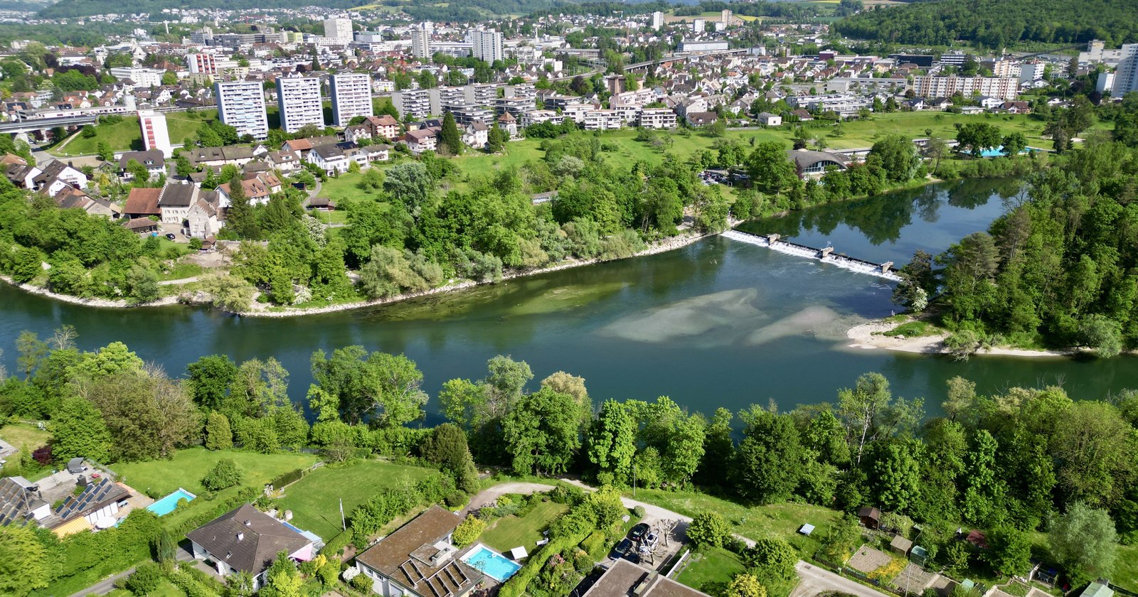 Luftaufnahme von Umiken mit der Aare, dem Wehr und der Stadt Brugg im Hintergrund